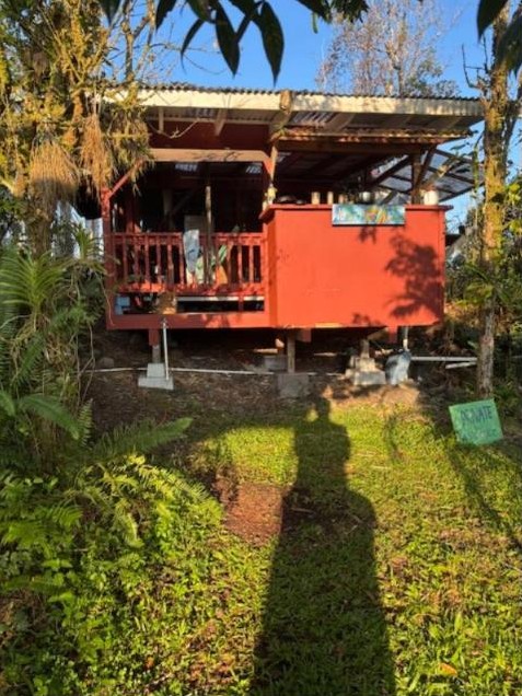 Raised red cabin with a covered porch